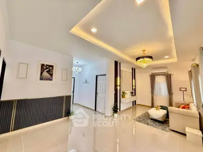 Elegant living room with modern chandelier and stylish decor, featuring a cozy seating area and polished tile flooring.