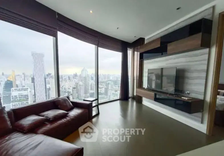 Luxurious living room with panoramic city view and modern furnishings in high-rise apartment.