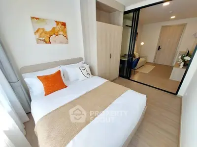 Modern bedroom with cozy decor and sliding glass doors leading to a stylish living area.