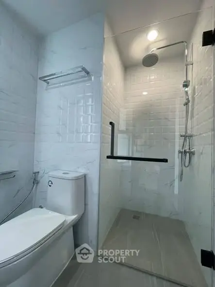 Modern bathroom with sleek shower and toilet in a contemporary design.