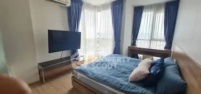 Modern bedroom with large windows and stylish decor in high-rise apartment.