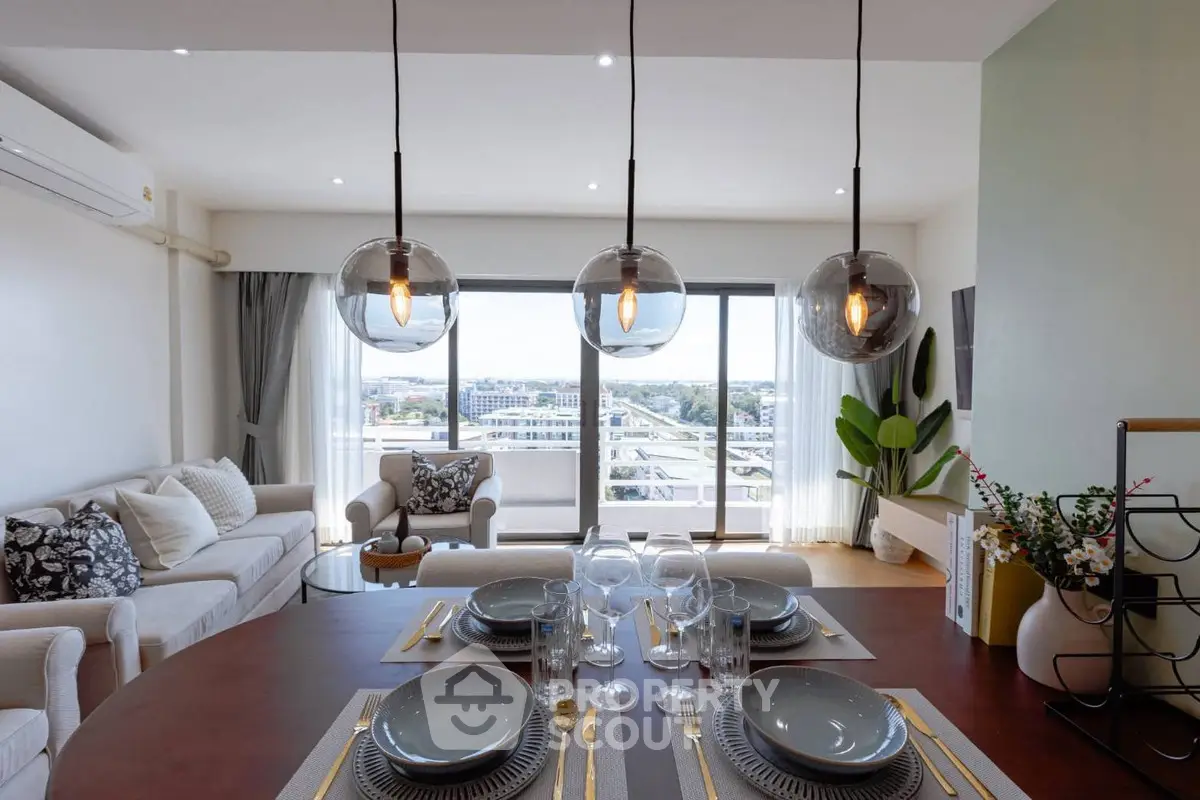Elegant living room with modern decor and large windows offering stunning city views.