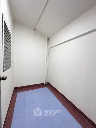 Spacious storage room with tiled floor and white walls, ideal for organizing belongings.