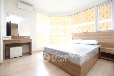 Modern bedroom with wooden furniture and large windows for natural light
