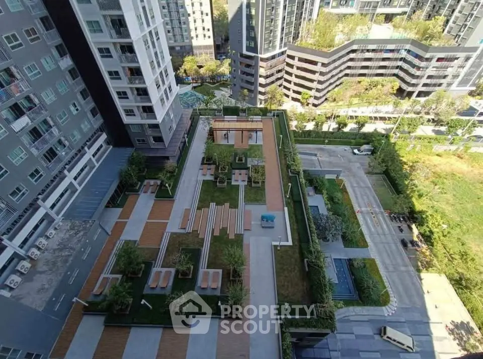 Stunning aerial view of modern apartment complex with lush rooftop garden and seating areas.