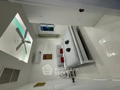 Modern bedroom with sleek design, featuring a ceiling fan, air conditioning, and stylish decor.