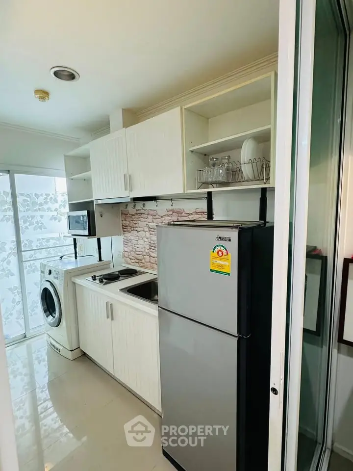 Modern kitchen with washing machine and fridge in compact layout