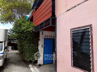 Charming urban building with vibrant blue door and lush greenery
