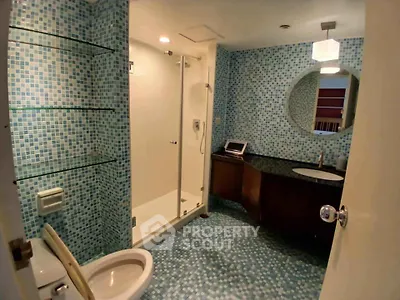 Modern bathroom with mosaic tiles and glass shower enclosure