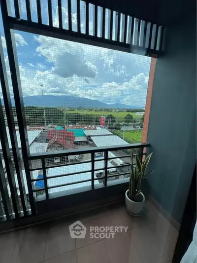 Charming balcony with scenic view of lush greenery and mountains, perfect for relaxation.