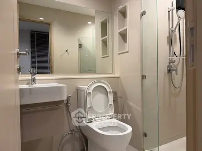 Modern bathroom with glass shower and sleek fixtures in a contemporary apartment.