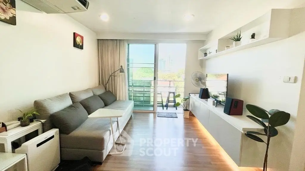 Modern living room with sleek furniture and balcony view, featuring stylish decor and natural light.