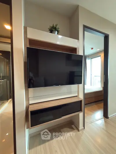 Modern apartment interior with wall-mounted TV and wooden flooring