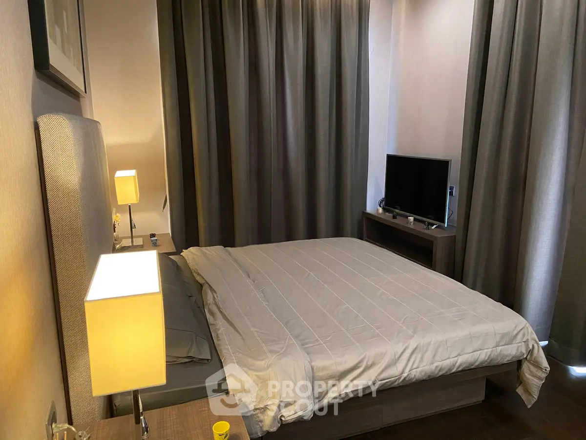 Cozy bedroom with modern decor and soft lighting, featuring a comfortable bed and a flat-screen TV.