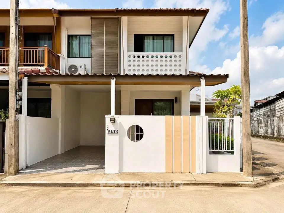Modern two-story townhouse with unique facade and gated entrance in a quiet neighborhood.