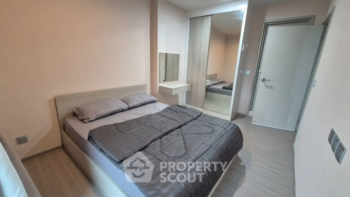 Modern bedroom with sleek design and mirrored wardrobe in a stylish apartment.