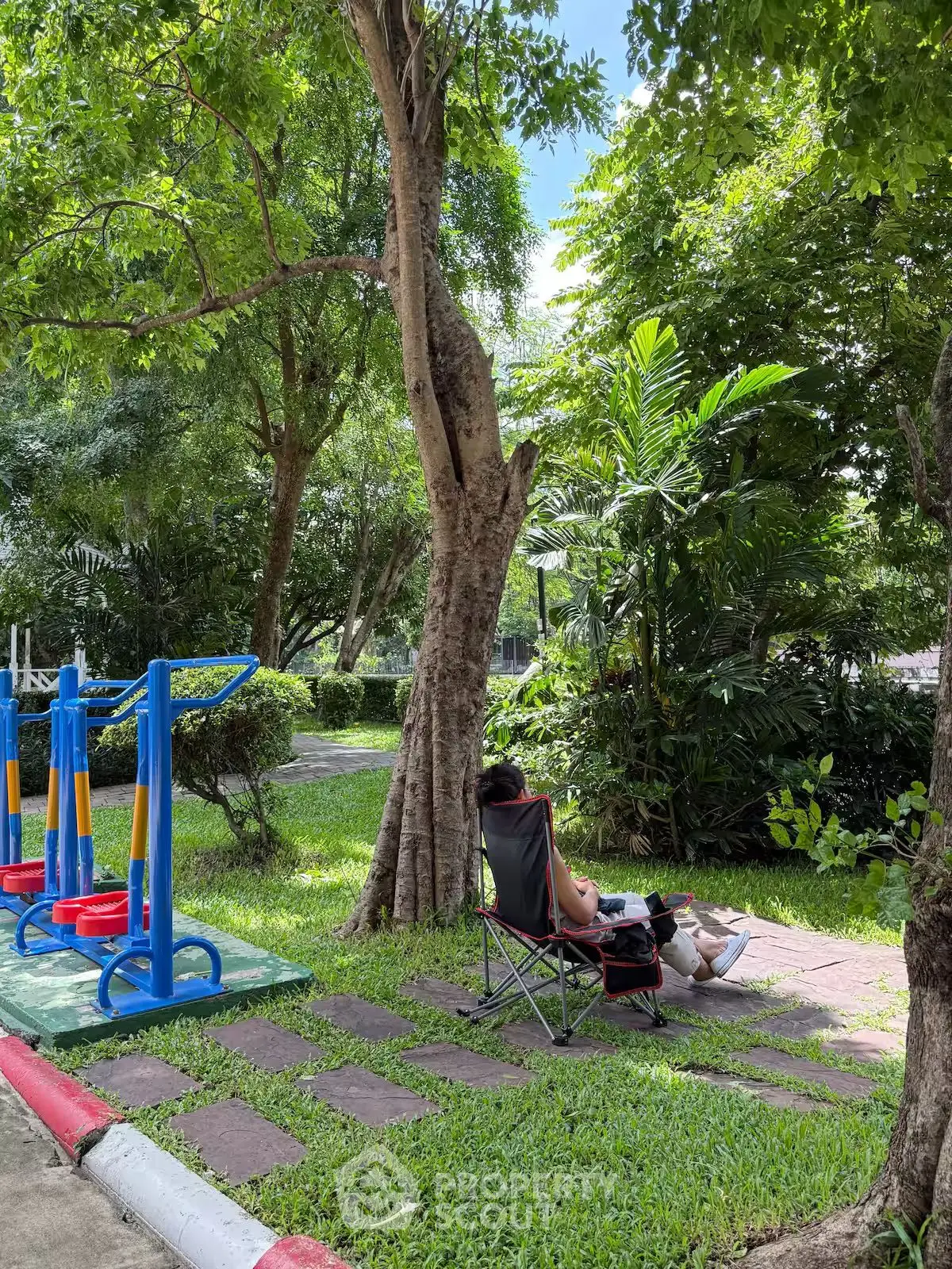 Serene garden area with lush greenery and a relaxing seating spot.