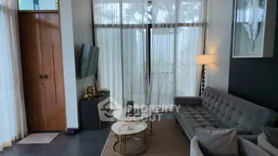 Elegant living room with modern decor, large windows, and cozy seating area.