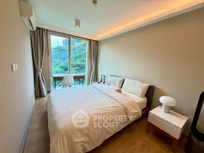 Cozy bedroom with large window and scenic view, featuring modern furniture and ambient lighting.