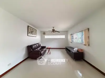 Spacious living room with modern decor and ceiling fan