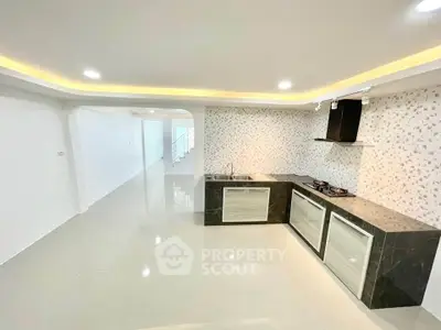 Modern kitchen with sleek design and open layout, featuring a gas stove and stylish backsplash.