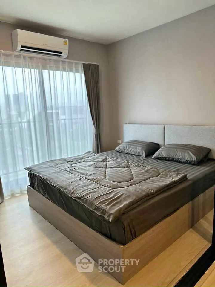 Modern bedroom with large window and stylish bed in a contemporary apartment.