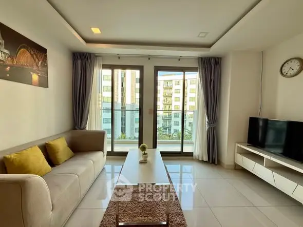 Modern living room with balcony view, stylish decor, and natural light.