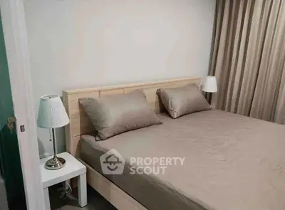 Cozy bedroom with modern decor and neutral tones, featuring a comfortable bed and stylish lamps.
