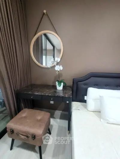 Elegant bedroom with stylish decor and cozy ambiance, featuring a chic mirror and comfortable seating.