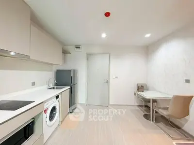 Modern kitchen with sleek appliances and stylish dining area in a contemporary apartment.
