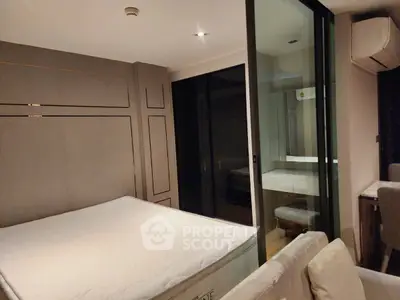 Modern bedroom with sleek design and glass partition, featuring a comfortable bed and stylish decor.