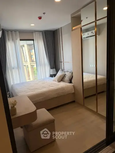 Modern bedroom with large window and mirrored wardrobe in stylish apartment
