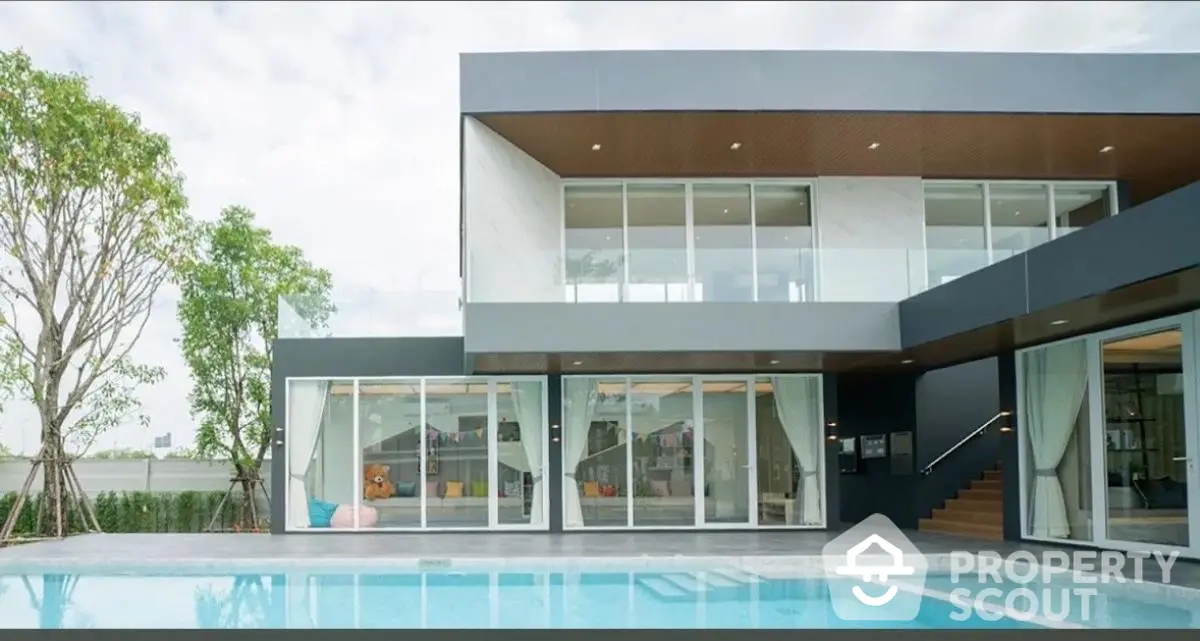 Modern luxury villa with pool and large glass windows, perfect for contemporary living.