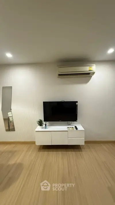Modern living room with sleek TV setup and air conditioning unit.