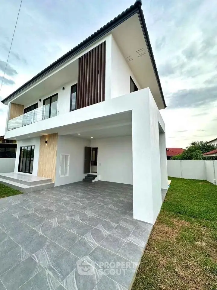 Modern two-story house with sleek design and spacious outdoor area, perfect for family living.