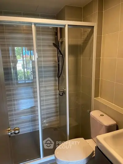 Modern bathroom with glass shower enclosure and sleek fixtures.