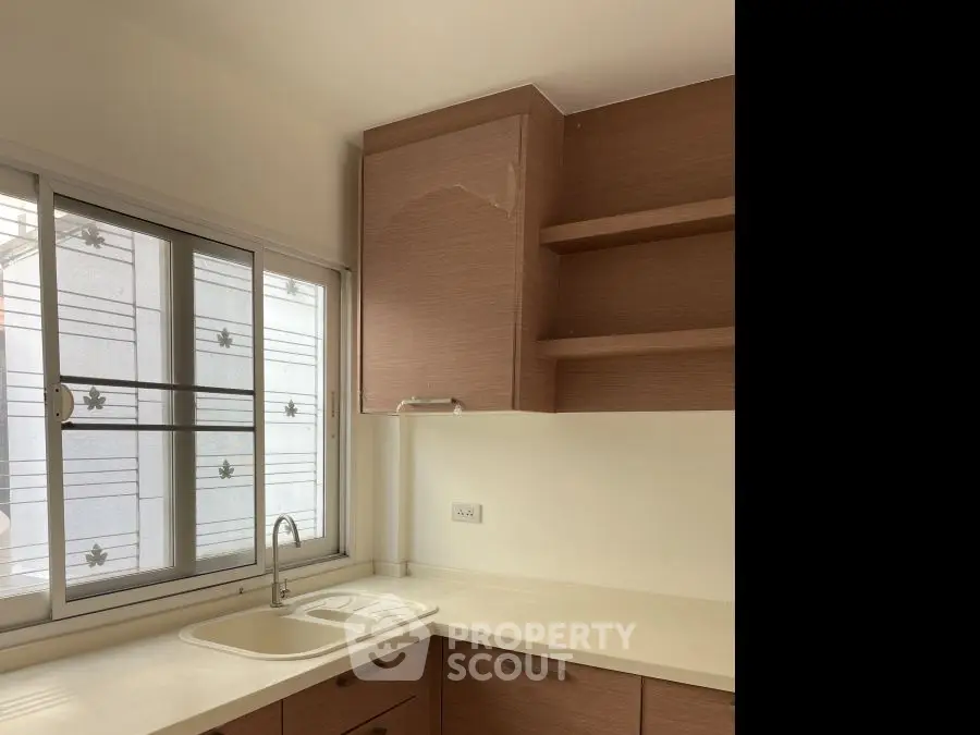 Modern kitchen with sleek cabinetry and large window for natural light.