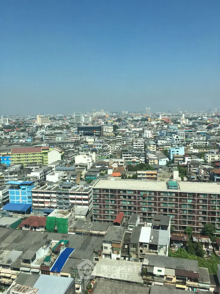 Panoramic cityscape view showcasing diverse urban architecture under a clear blue sky.