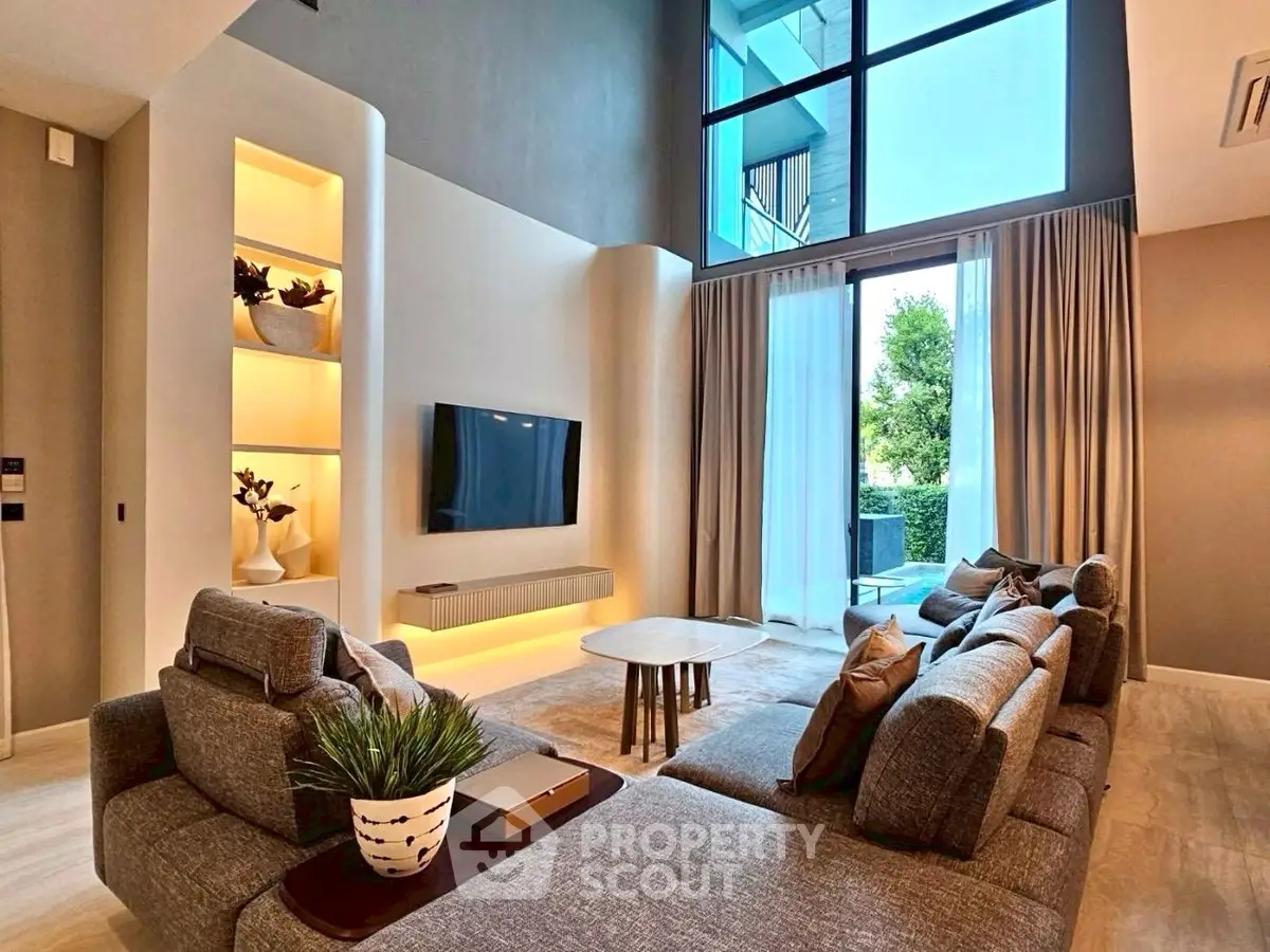 Luxurious modern living room with high ceilings and large windows offering natural light and garden view.