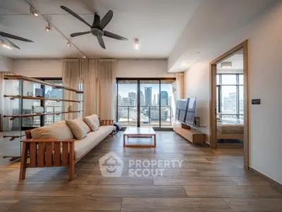 Spacious modern living room with city view, wooden flooring, and stylish furniture.