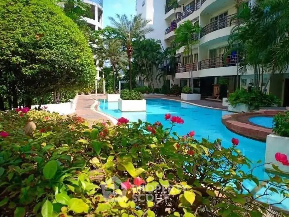 Luxurious apartment complex with lush gardens and inviting swimming pool.
