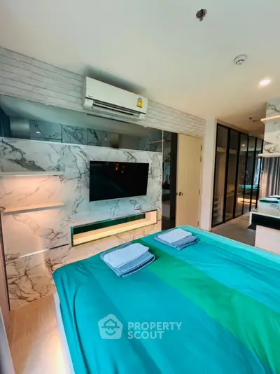 Modern bedroom with stylish marble accents and cozy teal bedding