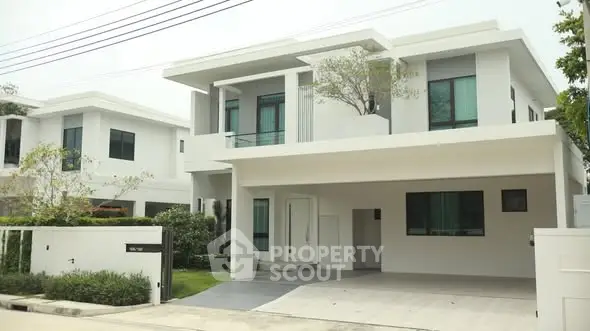 Modern two-story house with sleek design and spacious driveway in a serene neighborhood.