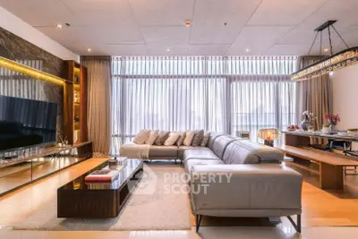 Luxurious living room with modern decor, large sectional sofa, and floor-to-ceiling windows offering abundant natural light.