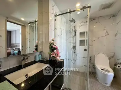 Luxurious bathroom with glass shower and elegant marble tiles