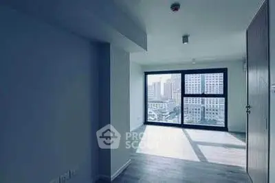 Spacious apartment with large windows offering city views and abundant natural light.