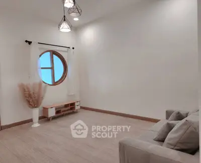Minimalist living room with round window and modern lighting