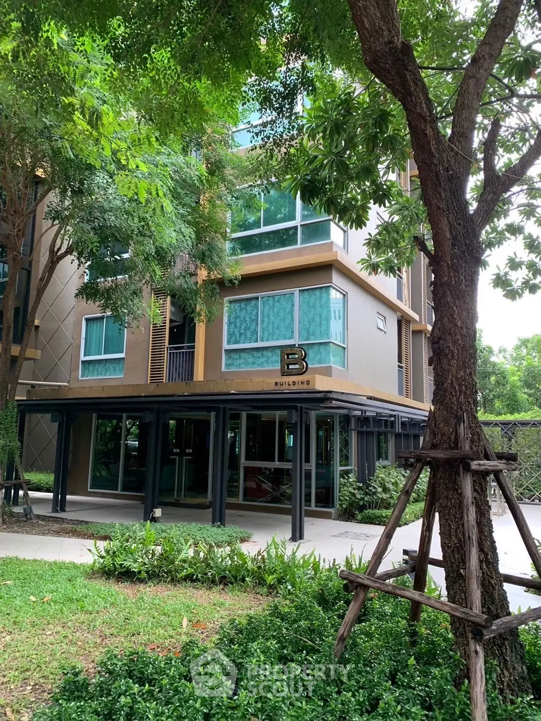 Modern residential building exterior with lush greenery and contemporary design.