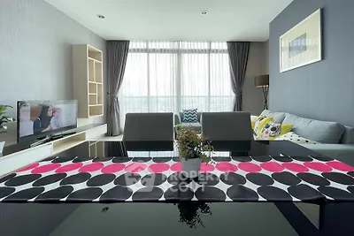 Modern living room with stylish decor and large windows offering natural light.
