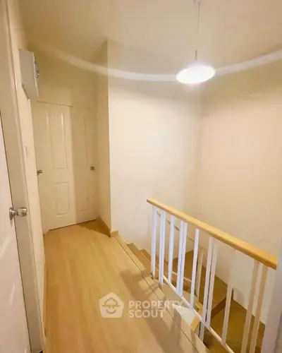 Bright hallway with wooden flooring and staircase in modern home